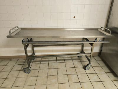 une table à roulettes en acier inoxydable dans une pièce