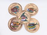 four plates with fish painted on them on a white surface