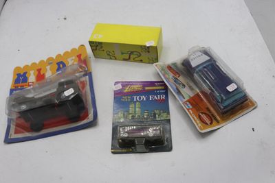 Plusieurs petites voitures sont posées sur une table, à côté d'une boîte de jouets