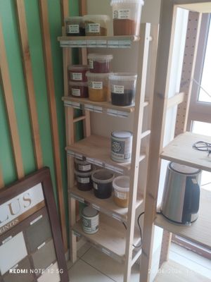 a shelf with jars and jars on it in the corner of a room