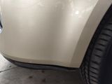 the front bumper of a car with a denting dent on it