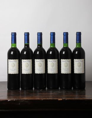 six bouteilles de vin sont alignées sur une table en bois