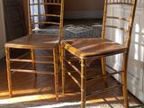 two wooden chairs sitting next to each other in a room