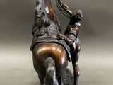 bronze statue of a man on a horse with a boy on the back