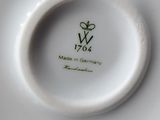 a close up of a white plate with a green design on it