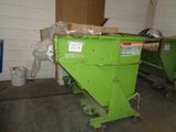 a green dumpster sitting in a room with a lot of boxes