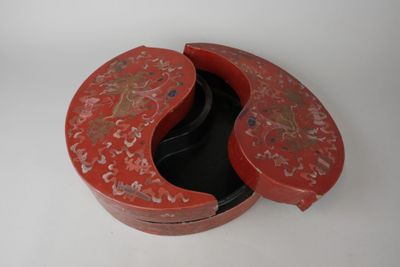 une boîte rouge dont le couvercle est orné d'un motif