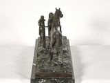 bronze statue of a man and a horse on a stone base