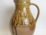 a brown pitcher sitting on a table with a white background