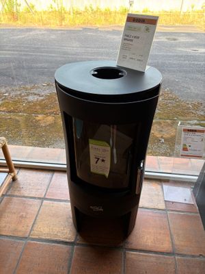 a black trash can sitting in front of a window