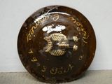 a brown plate with writing on it with a fish on it