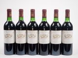 six bouteilles de vin rouge alignées sur une surface blanche