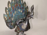 un oiseau en métal posé sur une surface blanche