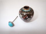 a small vase with a turquoise stone in it