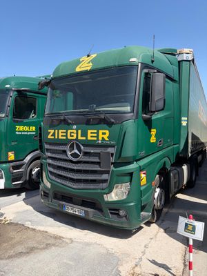 deux camions verts garés l'un à côté de l'autre sur un parking