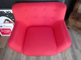 red chair in front of a cardboard box on a wooden floor