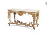 une console ancienne dotée d'un plateau en marbre et de sculptures ouvragées