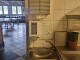a kitchen with a sink and a counter with a paper towel dispenser on it