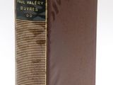 an old book with a brown cover sitting on top of a white surface