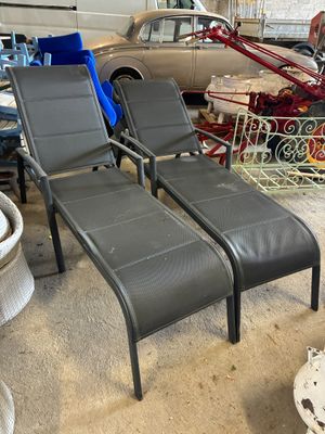 deux chaises longues et une table dans un garage, avec une voiture en arrière-plan