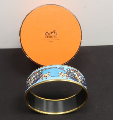 an orange box with a blue and gold bracelet sitting on top of a black table