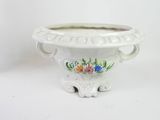 a white planter with flowers painted on it