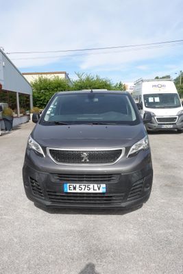 une camionnette noire garée sur un parking à côté d'une camionnette blanche