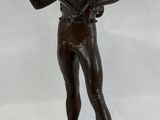 bronze statue of a man holding a gun on a wooden platform