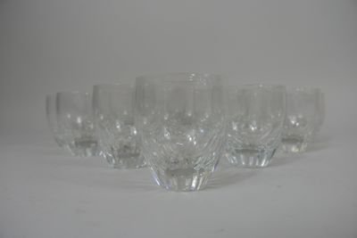six wine glasses lined up on a white surface