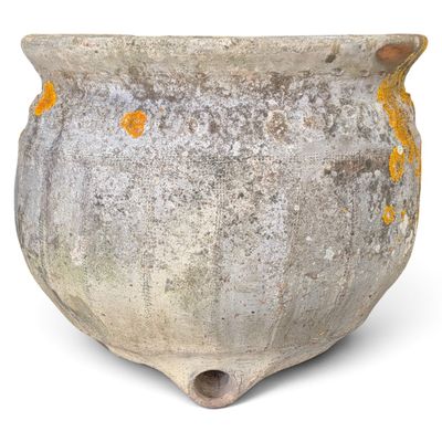 an old pot that is sitting on a white surface