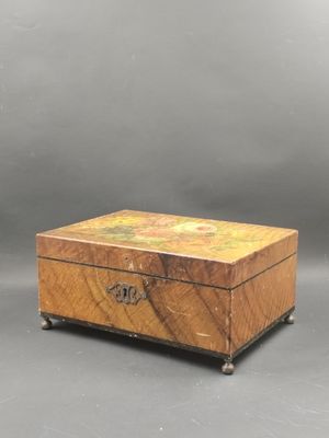une vieille boîte en bois posée sur une surface grise
