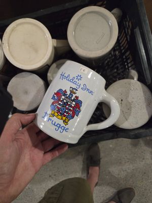 une personne tenant une tasse à café sur laquelle figure une image