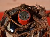 rope wrapped around a wine bottle with a red cap