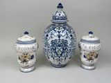 three blue and white vases and a jar with flowers on them