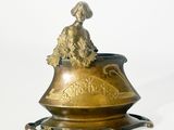 un vase en or surmonté d'un oiseau