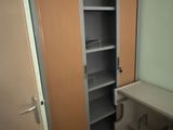 un placard situé dans un coin d'une pièce où se trouvent un bureau et une chaise