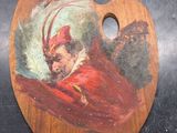un tableau représentant un homme vêtu d'un manteau rouge, assis sur une palette en bois