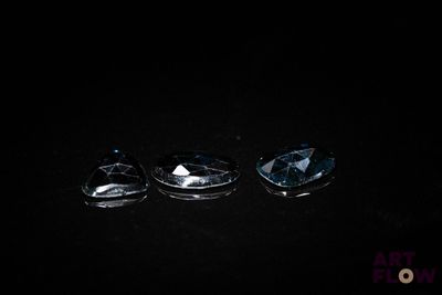 three blue topazte faceted stones on a black background