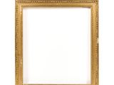 un cadre photo doré sur un mur blanc avec un fond blanc