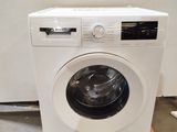 an image of a washing machine sitting on a pallet in a room