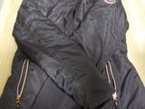 the jacket is black and has gold zippers on the sleeves