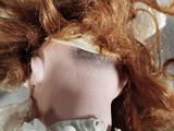a close up of a doll ' s head with red hair