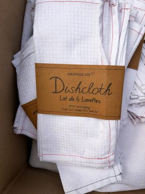 a cardboard box filled with white towels and a brown tag