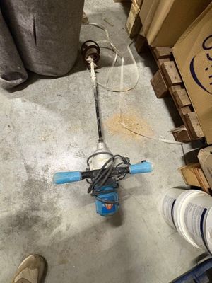 une personne debout à côté d'une pompe à eau bleue et blanche