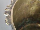 a silver pot with a handle on a white table