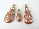 three copper colored ornaments on a white surface