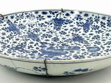 blue and white bowl with floral design on it on a white surface