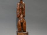une image représentant une sculpture en bois d'une femme tenant une boîte