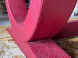 a close up of a pink chair on a carpeted floor