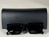 une paire de lunettes de soleil noires posée sur un étui noir